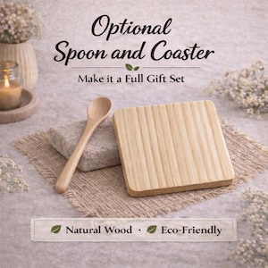 K&ouml;nnte beinhalten: Ein heller Holzl&ouml;ffel und ein quadratischer Holzuntersetzer mit vertikaler Maserung. Der Text lautet Optional Spoon and Coaster, Make it a Full Gift Set sowie Natural Wood, Eco-Friendly. Die Gegenst&auml;nde liegen auf einem strukturierten Stoff.