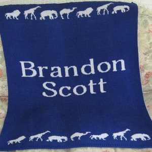 May include: Blue knitted baby blanket with white animal silhouettes and the name "Brandon Scott" embroidered in white.