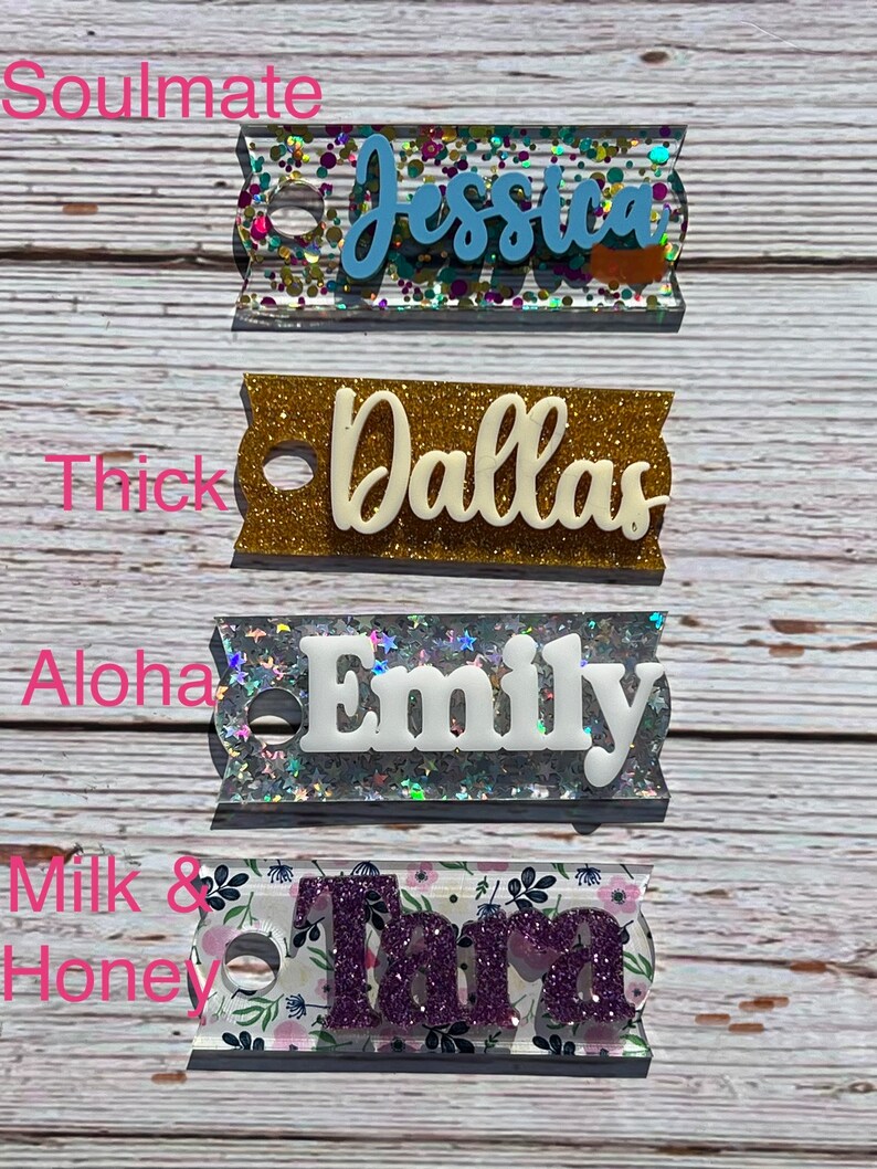 Puede incluir: Cuatro etiquetas de nombre personalizadas con purpurina y diferentes patrones. Los nombres son Jessica, Dallas, Emily y Tara. Las etiquetas son todas rectangulares y tienen un agujero en la parte superior para colgar.