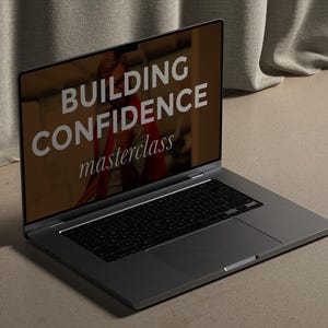 May include: A laptop computer with a gray exterior and a black keyboard. The screen displays the text "BUILDING CONFIDENCE masterclass".