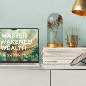 May include: A laptop computer with a screen displaying the text "Master Awakened Wealth masterclass". The screen shows a woman with wings surrounded by money. The laptop is on a white desk with books and a decorative glass dome.