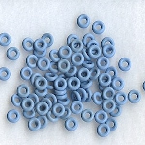 May include: A pile of light blue plastic jump rings. The rings are about 1/2 inch in diameter.