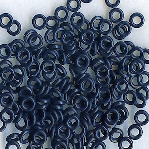 May include: A large pile of dark blue rubber O-rings.