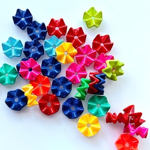 May include: Assortment of colorful plastic flower-shaped buttons in various colors, including red, yellow, blue, green, and purple.
