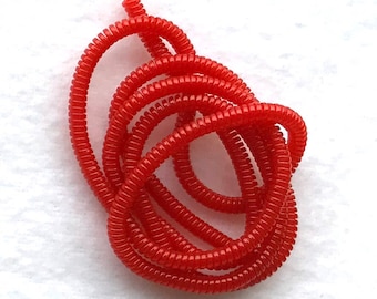 May include: A coil of bright red plastic cord, perfect for organizing and protecting wires and cables.