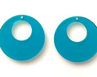May include: A pair of turquoise blue acrylic earrings with a circular shape and a hole in the center for hanging.