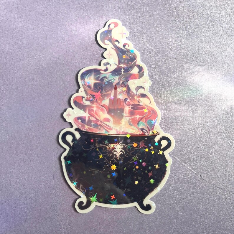 May include: A holographic sticker featuring a black cauldron with ornate patterns and colorful star accents. Rising from the cauldron is a swirling, multi-colored vapor cloud with a hand emerging from the center, displaying a middle finger gesture.