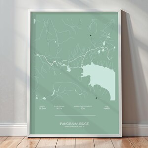 May include: A green and white map of Panorama Ridge, a hiking trail in Canada. The map shows the trail's elevation, distance, and difficulty level. The text on the map reads "Panorama Ridge, Canada's Continental Divide, Made It!"