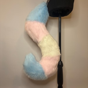 May include: A white ceramic mug with a black handle and the text "But First, Coffee" in a bold, black font. The mug is set against a blurred background, suggesting a cozy setting.