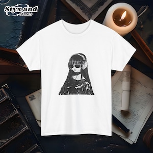 Op de afbeelding: Wit T-shirt met een zwart-witte illustratie van een vrouw met een koptelefoon en zonnebril.