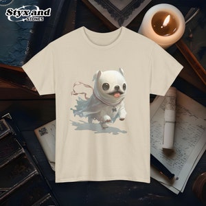 May include: Beige t-shirt featuring a whimsical illustration of a small, white pug dog wearing a ghost-like white cloak. The pug has large, dark eyes and its tongue is playfully sticking out. The image is rendered in a painterly style with soft shading and subtle details. The overall aesthetic is cute and slightly spooky, suitable for Halloween or other whimsical occasions. The t-shirt is a light, neutral color, providing a clean backdrop for the illustration.