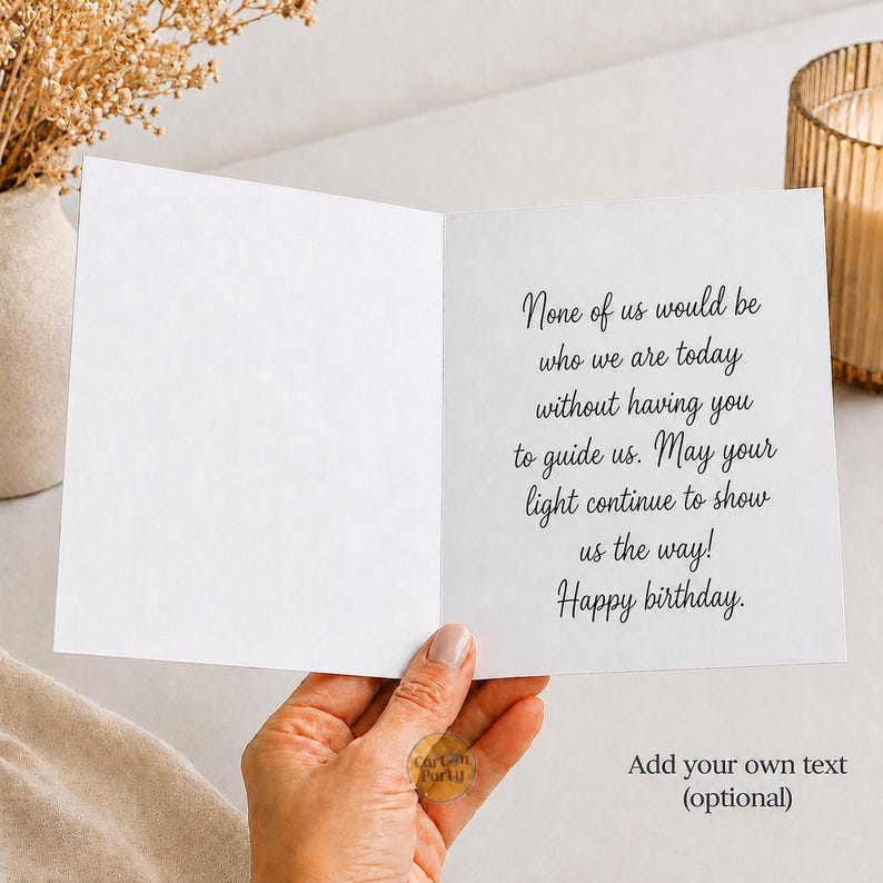 May include: A white greeting card held open, featuring black cursive text that reads: None of us would be who we are today without having you to guide us. May your light continue to show us the way! Happy birthday. The card includes an optional text area.