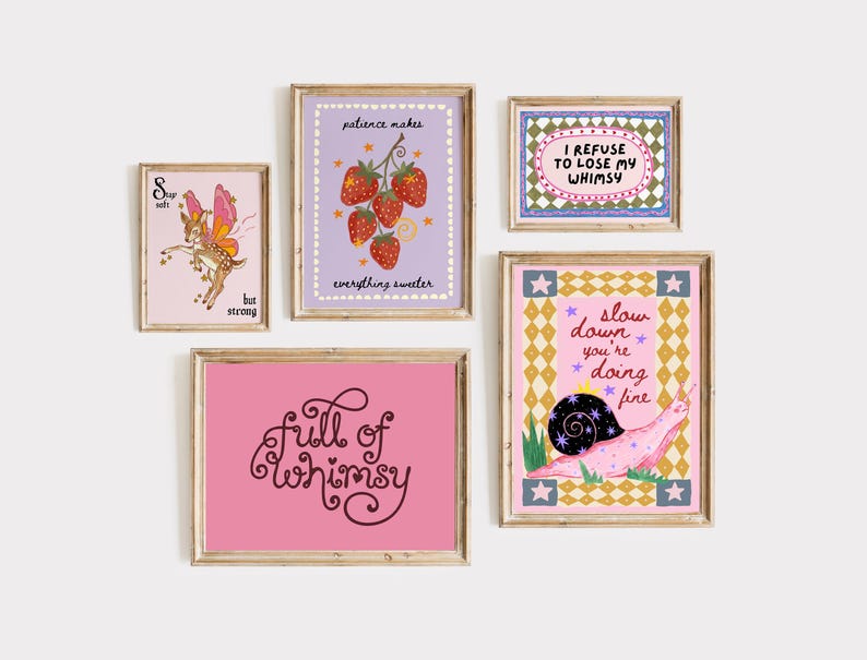 May include: A collection of five framed wall art prints featuring whimsical illustrations and text. The prints include a fairy deer, strawberries with the text 'patience makes everything sweeter', a snail with 'slow down you're doing fine', and text-based art.