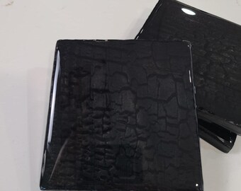 May include: Set of three black square coasters with a cracked, textured surface. The coasters have a glossy finish.