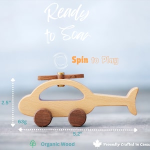 May include: Wooden toy helicopter, 2.5 inches tall and 5.2 inches long, with brown wheels and rotor. The text "Ready to Soar" and "Spin to Play" are visible. The toy weighs 63g and is made of organic wood.