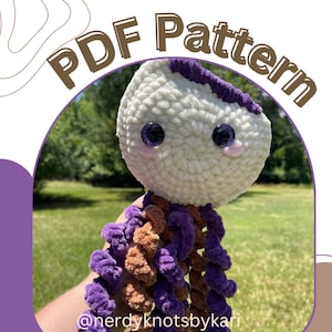 Puede incluir: Un juguete de peluche de pulpo de crochet con una cabeza blanca, tentáculos morados y marrones y grandes ojos negros. El juguete está sentado en una cama de hierba verde. El texto "PDF Pattern" está escrito en letras marrones sobre un fondo blanco.