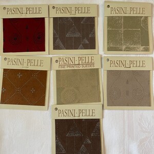 Może przedstawiać: Sześć próbek tkaniny z różnymi wzorami i kolorami. Próbki są oznaczone "Pasini-Pelle Fine Printed Suedes".