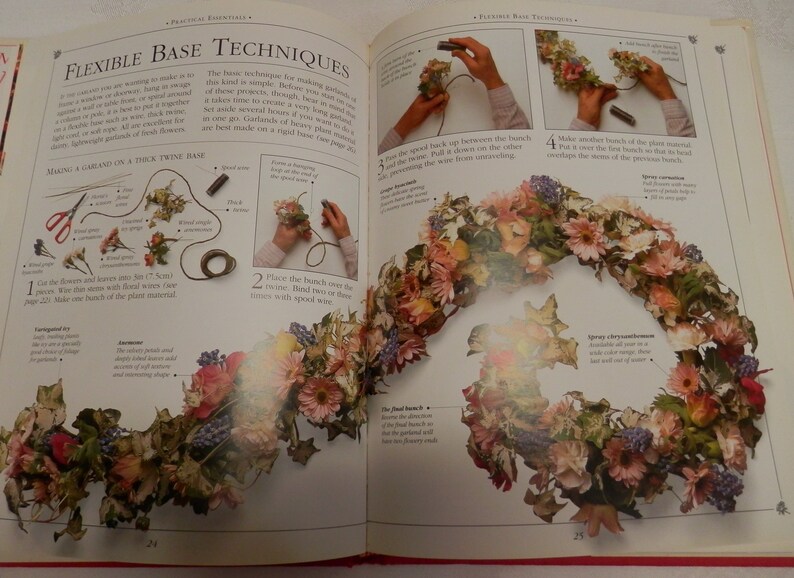 May include: A book page with instructions on how to make a floral garland using a flexible wire base. The image shows a close-up of the wire base with flowers and leaves attached to it. The text on the page reads "Flexible Base Techniques".