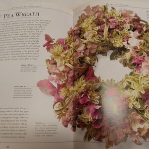 May include: A sweet pea wreath made with pink, white, and green flowers. The wreath is tied with a gold ribbon and is surrounded by text that says "Sweet Pea Wreath".
