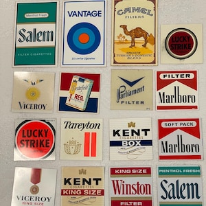 May include: A selection of vintage cigarette packet designs, including brands such as Salem, Camel, and Marlboro. The packets feature various colours, logos, and text, such as "Menthol Fresh" and "Filter Cigarettes."