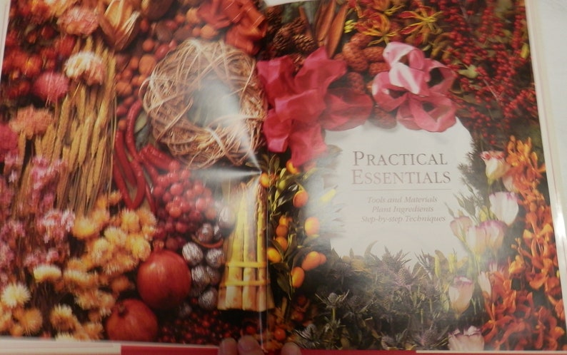 May include: A book titled "Practical Essentials" with a close-up image of various dried flowers, berries, and other natural elements. The book focuses on "Texts and Materials, Plant Ingredients, Step-by-Step Techniques".