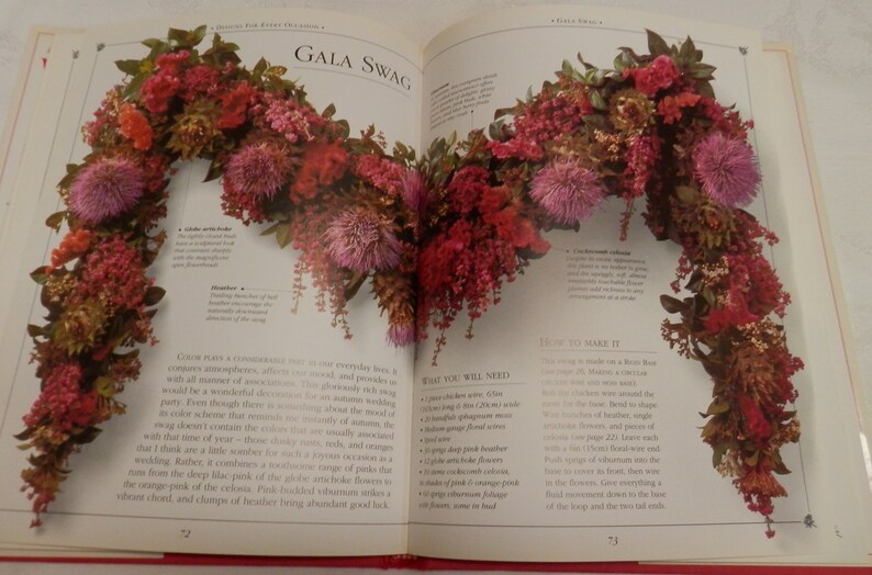 May include: A book page with a close-up image of a floral swag made with dried flowers in shades of pink, red, and brown. The text "Gala Swag" is at the top of the page. The text "What You Will Need" and "How To Make It" are also visible on the page.