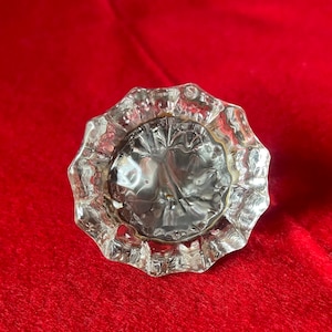 May include: A clear glass door knob with a faceted design.