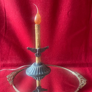 Può includere: Una candela decorativa con una candela finta e un designo di uccello su un vassoio a specchio dorato.