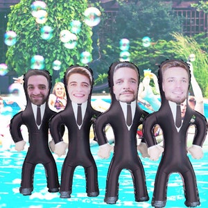 May include: Four inflatable pool floats shaped like people wearing black suits and ties. Each float has a different person's face printed on it.