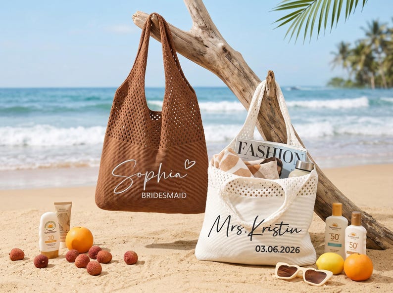 May include: Two beach tote bags, one brown and one white, are on a sandy beach. The brown bag has the name "Sophia" and "Bridesmaid" printed on it. The white bag has "Mrs. Kristin" and the date "03.06.2026" printed on it. Beach accessories are scattered around.