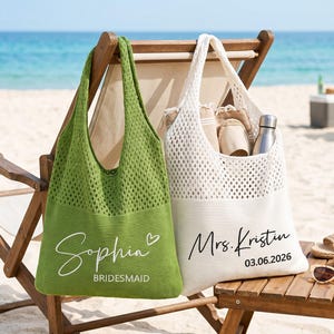 Könnte beinhalten: Zwei offene Netztaschen, eine grüne und eine weiße, werden auf einem hölzernen Strandstuhl präsentiert. Die grüne Tasche trägt den Namen "Sophia" und das Wort "Bridesmaid". Die weiße Tasche trägt den Namen "Mrs. Kristin" und das Datum "03.06.2026".