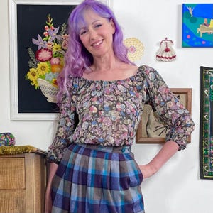 May include: A white ceramic mug with a black handle and the text "But First, Coffee" in a black, bold font. The mug is on a white surface.