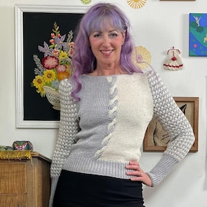 May include: A set of three ceramic mugs with a speckled, matte finish. The mugs are in shades of cream, light gray, and dark gray. Each mug has a simple, minimalist design and a rounded handle.