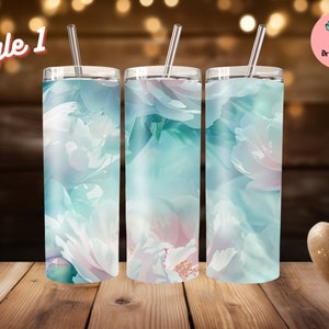 Könnte beinhalten: Drei Edelstahlbecher mit floralen Designs. Die Becher haben ein hellblaues, rosa und weißes Blumenmuster. Jeder Becher hat einen silbernen Deckel und einen durchsichtigen Strohhalm. Der Text "Style 1" befindet sich in der oberen linken Ecke.