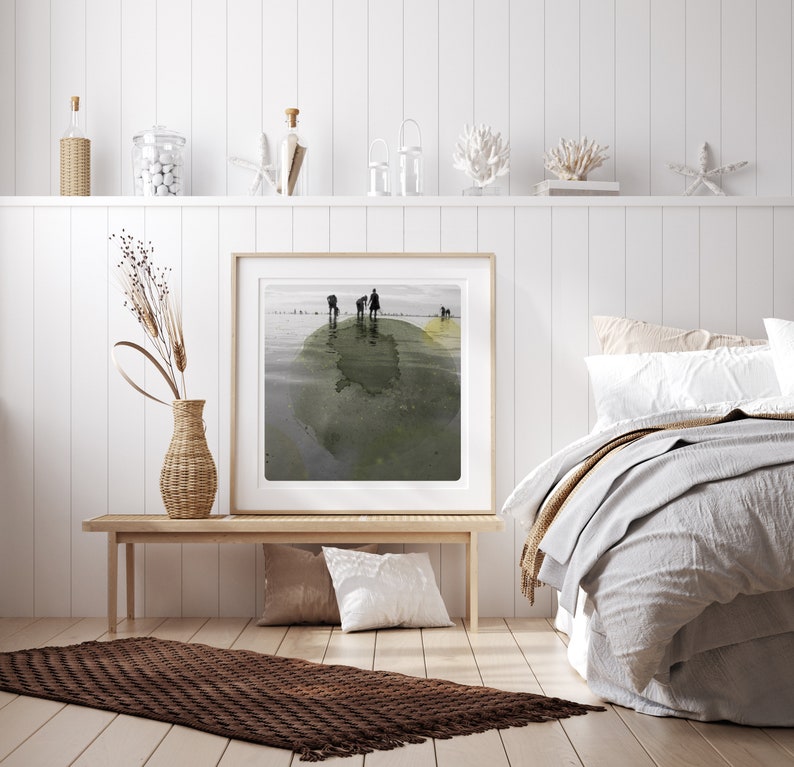 K&ouml;nnte beinhalten: Ein gerahmtes abstraktes Gem&auml;lde mit einem gr&uuml;nen und gelben Aquarelldesign. Das Gem&auml;lde zeigt eine Gruppe von Menschen, die auf einer kleinen Insel inmitten eines Gew&auml;ssers stehen. Das Gem&auml;lde h&auml;ngt an einer wei&szlig;en Wand &uuml;ber einer Holzbank.