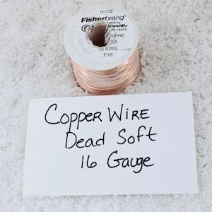 May include: A spool of copper wire, labeled "Fisherbrand", with the text "16 OZ" and "16 AWG". A handwritten note reads "Copper Wire Dead Soft 16 Gauge". The wire is a warm copper color.
