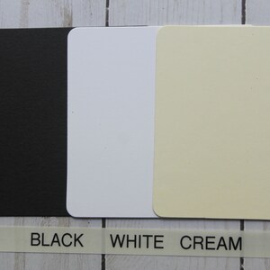 Puede incluir: Tres tarjetas rectangulares en negro, blanco y crema con esquinas redondeadas. Debajo, una etiqueta blanca con las palabras "BLACK", "WHITE" y "CREAM" impresas en negro.