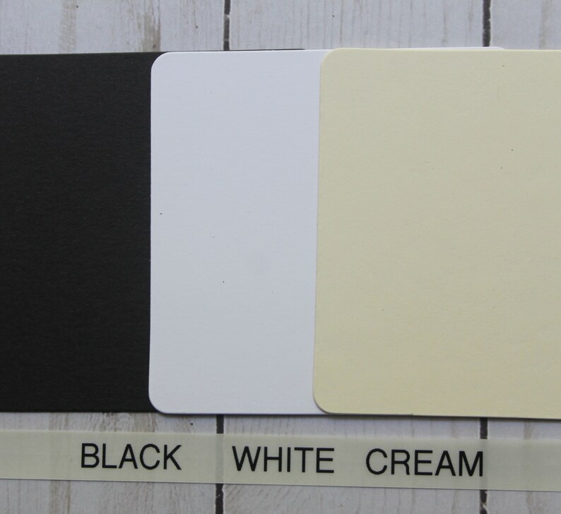 Puede incluir: Tres tarjetas rectangulares en negro, blanco y crema con esquinas redondeadas. Debajo, una etiqueta blanca con las palabras "BLACK", "WHITE" y "CREAM" impresas en negro.