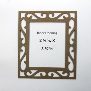 May include: A brown wooden picture frame with an ornate design. The inner opening measures 2 5/8" wide by 3 1/4" high.