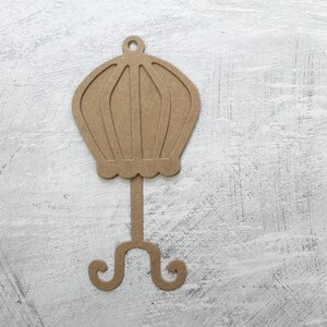 May include: A brown cardboard cutout of a vintage hat stand with a round top and a three-legged base.