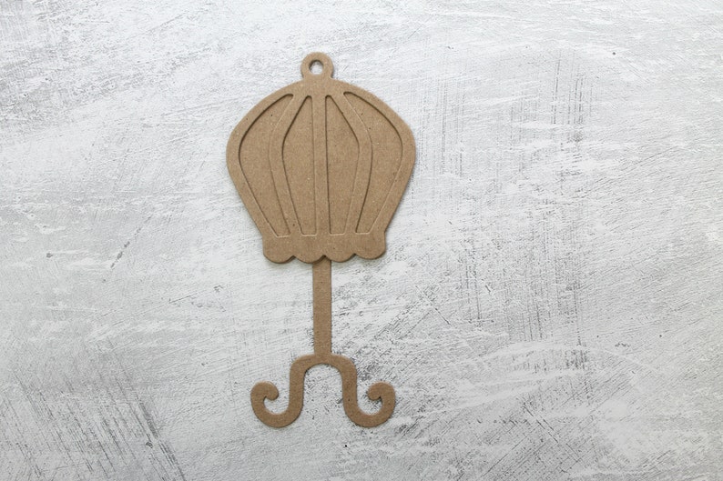 May include: A brown cardboard cutout of a vintage hat stand with a round top and a three-legged base.