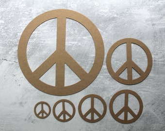 May include: Six brown paper peace signs of varying sizes, arranged in a row on a gray textured background.