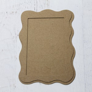 May include: A brown cardboard frame with a wavy edge. The frame is blank and ready for a photo or artwork.