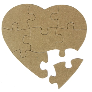 May include: A brown cardboard heart-shaped jigsaw puzzle with one piece missing. The puzzle is made of multiple pieces that fit together to form the shape of a heart.