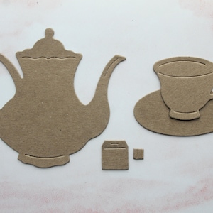 May include: A brown paper cutout of a teapot, a teacup and saucer, and a tea bag.