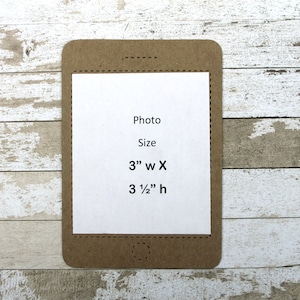 May include: A brown cardboard photo frame with a white insert. The insert has the text "Photo Size 3" w X 3 1/2" h".