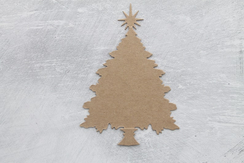 May include: A brown cardboard cutout of a Christmas tree with a star on top, against a light gray background.
