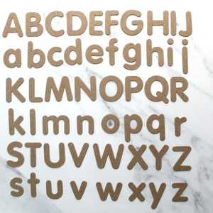 May include: A full alphabet set of brown cardboard letters, both uppercase and lowercase. The letters are arranged in rows, with the uppercase letters on top and the lowercase letters below.