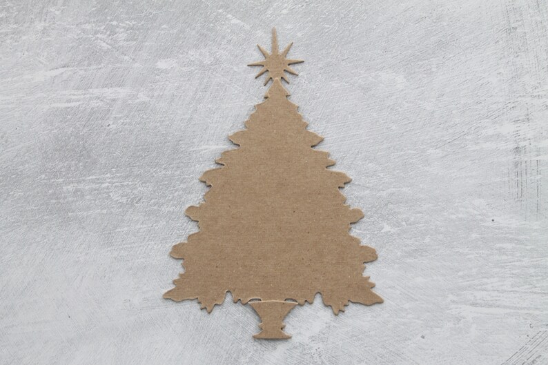 May include: A brown paper Christmas tree cutout with a star on top. The tree is on a gray background.