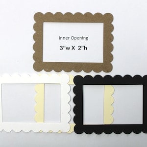 May include: Three scalloped picture frames in white, black, and brown with a 3 inch by 2 inch opening. The frames are made of cardstock and are perfect for adding a touch of whimsy to your crafts.